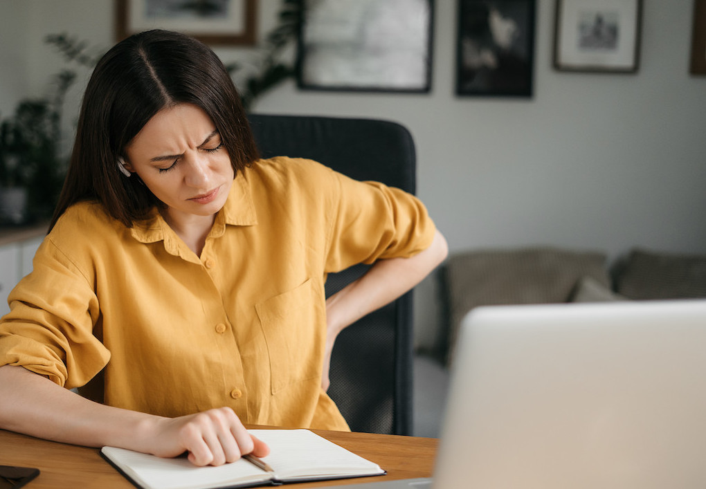 female experiencing lower back pain due to poor posture