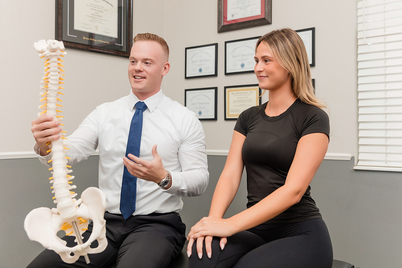 Dr. Jacob Henricksen showing patient a full spine model